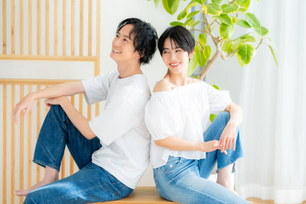 istock Young couple sitting close together back to back 1989135560