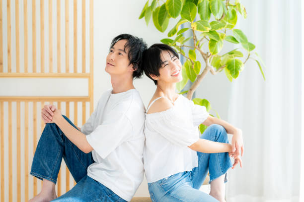 Young couple sitting close together back to back