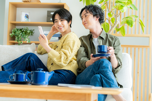 Couple relaxing at home with smartphone in hand