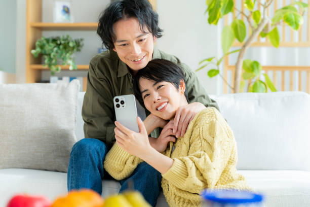 istock Couple relaxing at home with smartphone in hand 1989135689