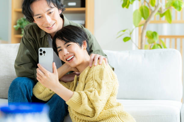 istock Couple relaxing at home with smartphone in hand 1989135690