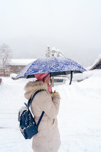 Beautiful woman tourists enjoying their trip with thick snow Japan at winter