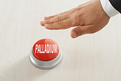 Businessman pushing “Palladium“ button on a table top symbolizing business investment