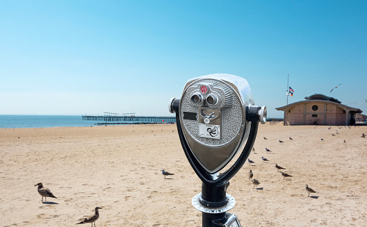 Coin operated binoculars in an empty beach on a sunny summer day