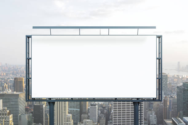 istock Blank white billboard on cityscape background at daytime, front view. Mock up, advertising concept 1989207506