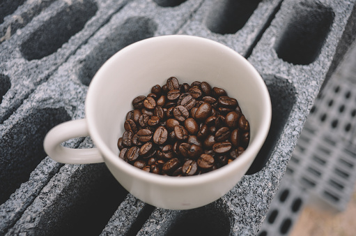 White cup of fresh hot coffee and coffee beans on the table, topview, flat lay.