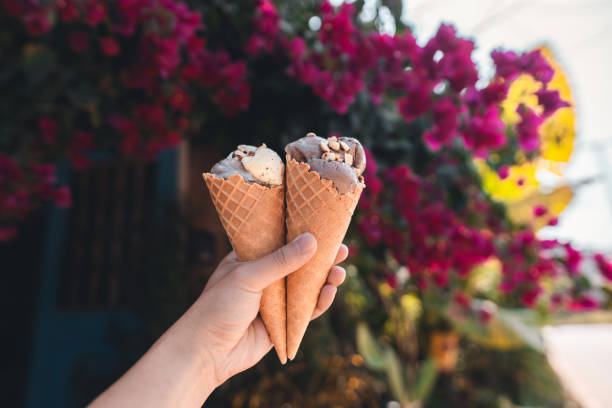 istock hand holding ice cream with flower background 1989238059