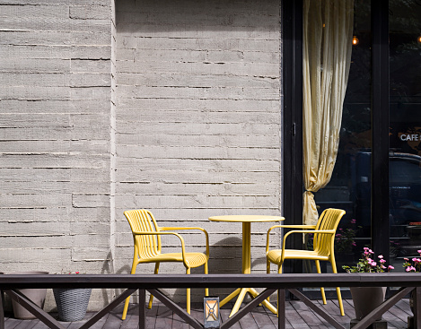 Yellow chairs and desks are located on the outdoor terrace.