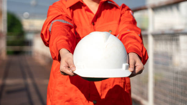 istock Giving a safety helmet. Safety first working concept. 1989307685