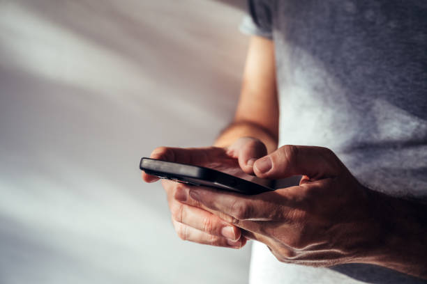 Man using modern smartphone portable information device to type text message Man using modern smartphone portable information device to type text message, selective focus txt stock pictures, royalty-free photos & images