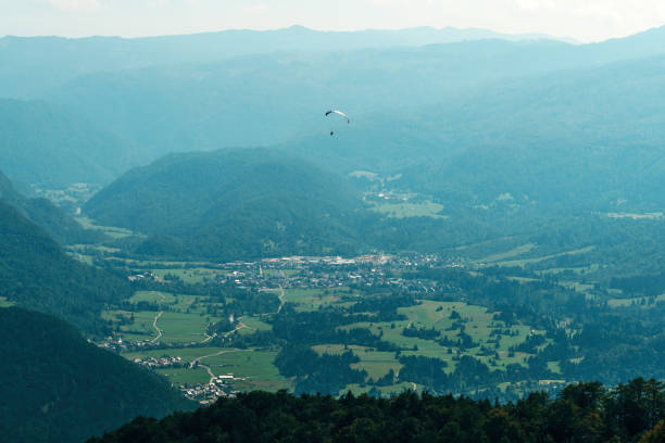 Paragliding over Lake Bohinj valley in summer, selective focus