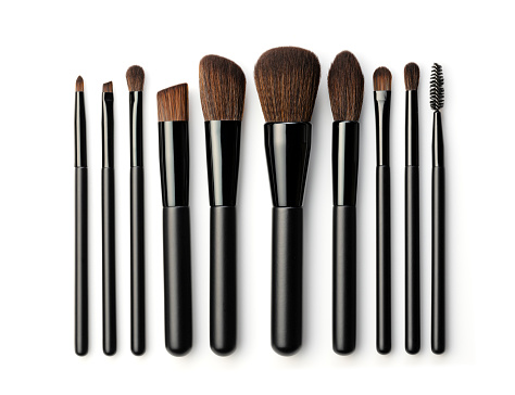 Set of black makeup brushes isolated on white background. Top view.