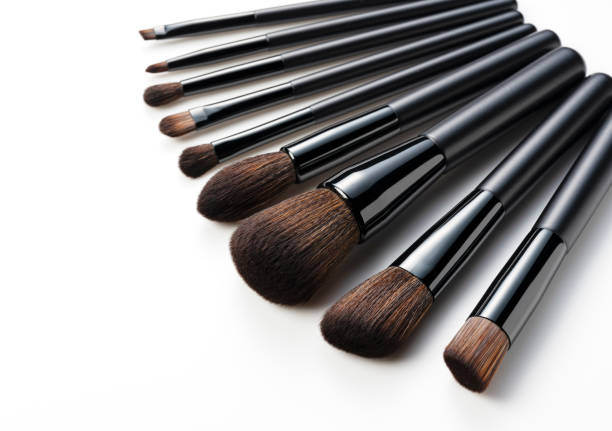 Set of black makeup brushes isolated on white background.