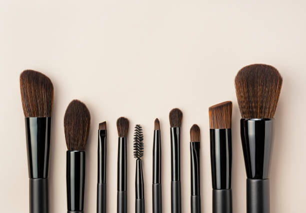 istock Set of black makeup brushes  on  beige background. Top view. 1989338220