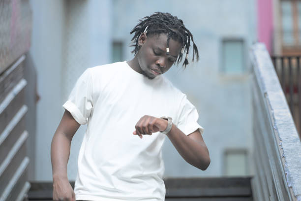 a young man with his hairstyle and the atmosphere of living in the community. - black ladder white staircase photos et images de collection