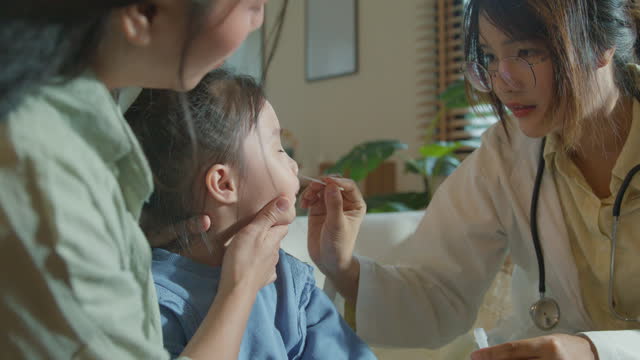Asian girl, who gets sick and has a high fever, does Nasal swabs from a doctor at home. Illness Girl stays with her mom with a medical condition and family wellness.