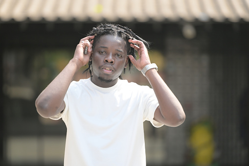 A young man with his hairstyle and the atmosphere of living in the community.