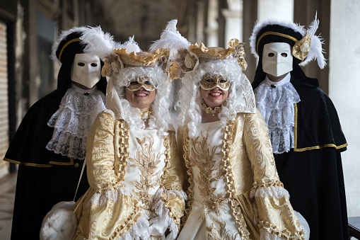 Venice, Veneto, Italy - January 28, 2024:Elegant Old Fashioned Venetian Mask Costumes on San Marco Square during Traditional Carnival
