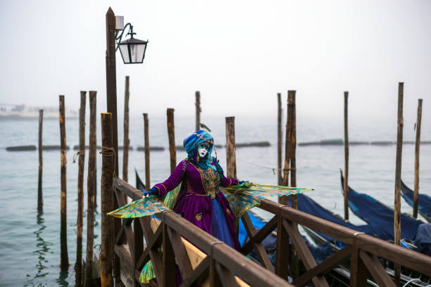 costume da maschera di carnevale veneziano pavone femminile che balla e posa sul lungomare di san marco - mardi gras carnival peacock mask foto e immagini stock