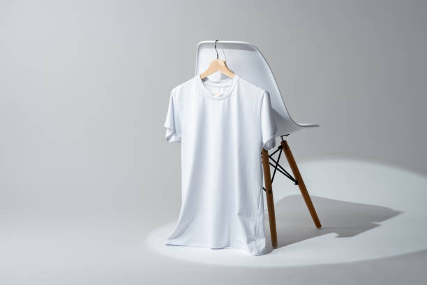 istock White blank t-shirt hanging on chair in empty room 1989372282