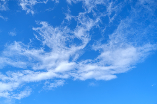 Clouds in a blue sky background add texture and depth to the expansive canvas of the sky, creating a dynamic and ever-changing scene.