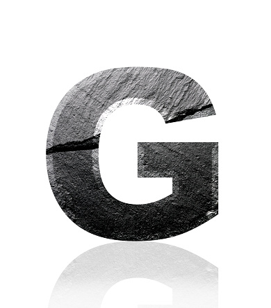 Close-up of three-dimensional slate alphabet letter G on white background.