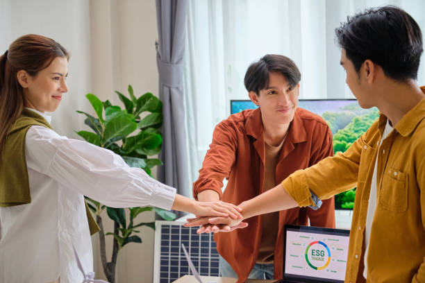 istock Group of Diversity business people joining stack hand teamwork unity,having a ESG meeting environment, society and governance, discussing renewable energy with wind turbine  and solar panel at office,Save the planet go green eco-friendly  net zero emissi 1989414458