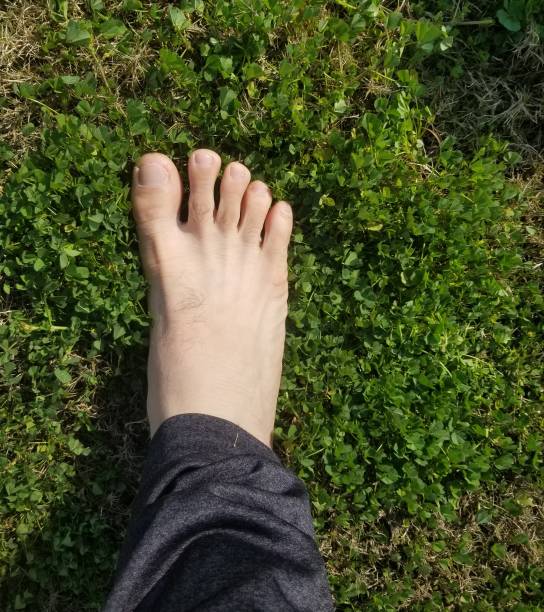 istock Man's Two feets on the green grass stock photo 1989452798