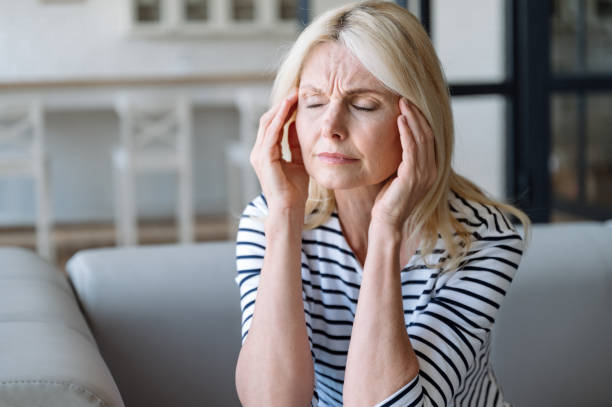 istock Portrait of mature woman touching temples and have problems with memory, 1989465307