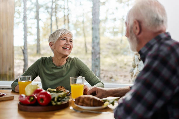 istock Happy mature woman talking to her husband during breakfast at dining table. 1989479582