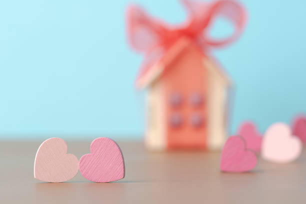 istock Decorative hearts over defocused background with house model with red bow 1989493750