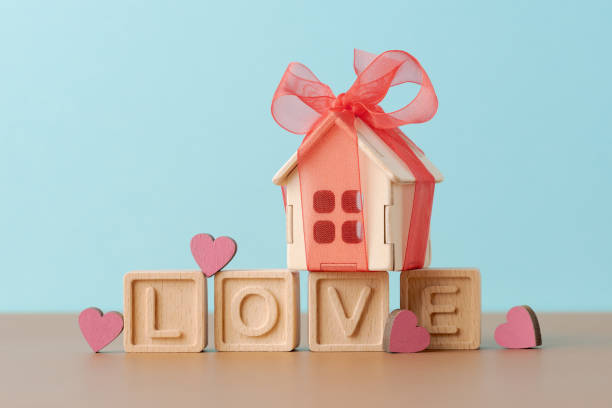 istock Gift of Love: Wooden House with Red Bow on Blocks Spelling LOVE 1989493752