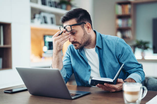 istock Stressed and tired man working at home 1989515957