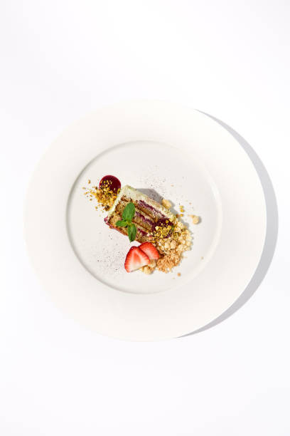 istock Pistachio cake with a raspberry layer and crumbled cookie-pistachio topping, isolated on a white background, top view 1989520197
