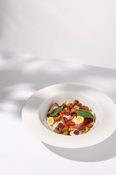 istock Roast Beef Salad with Quail Eggs and Vegetables on Shadowed White Presentation 1989521813