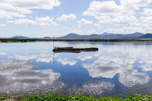 beautiful and spectacular lagoon landscape reflecting sky and mountains with boat in the middle in Mexico