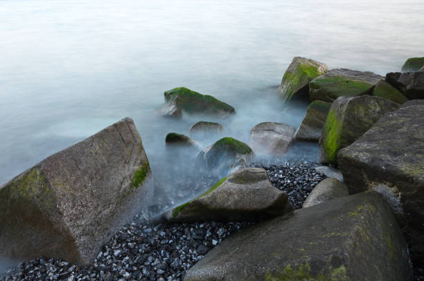Baltic sea, cold sea water. Waves about stones, Stones with water grass. Coastal stones