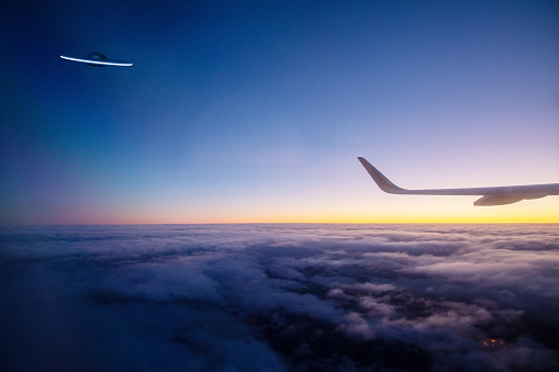 Many distant passenger jet planes flying on high altitude on clear blue sky leaving white smoke trace of contrail behind. Busy air transportation concept.