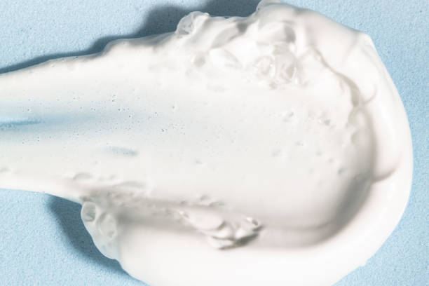 istock Sample of white cosmetic cream, foam, soap on a blue background, top view. Macro texture. 1989595452