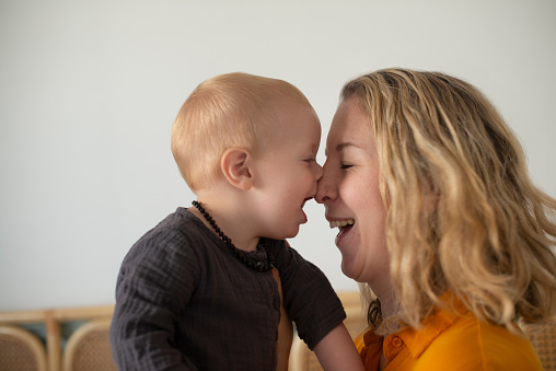 Mother and baby, love and nose kiss in a house for bonding, fun and morning games together. Happy family, playing and mom with son in a living room with support, trust and care, security and learning