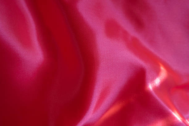 Crumpled vibrant reddish pink satin polyester fabric