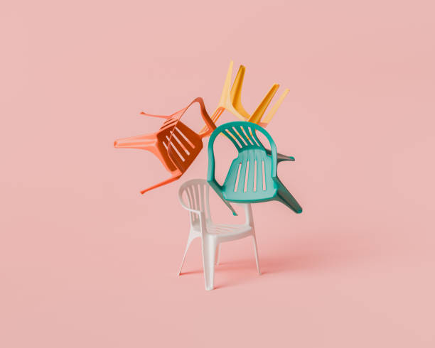istock Stacked Colorful Plastic Chairs on Pastel Pink Background 1989650517