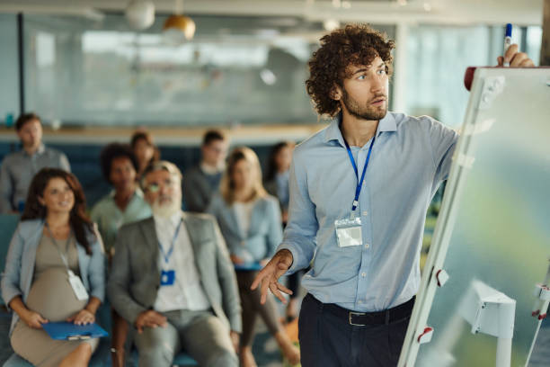 istock Young male CEO drawing plans during presentation in board room. 1989653721