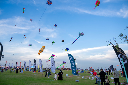 Doha, Qatar - Jan 26 2024: Spectators enjoy the large kites flying at Mina district in Qatar as part of Kite Festival 2024. Families and young children in Qatar enjoys the kite festival.