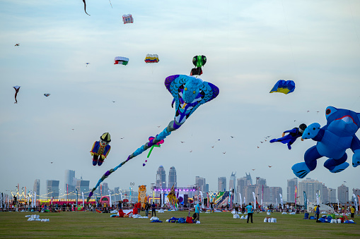 Doha, Qatar - Jan 26 2024: Spectators enjoy the large kites flying at Mina district in Qatar as part of Kite Festival 2024. Families and young children in Qatar enjoys the kite festival.