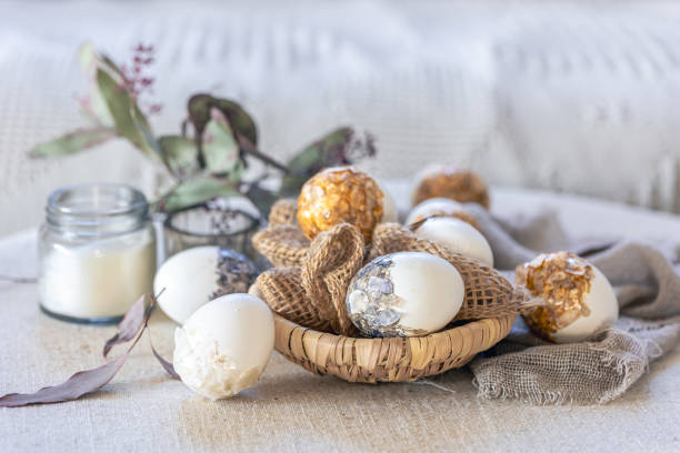 istock Easter background with creative eggs and candles close up. 1989665944