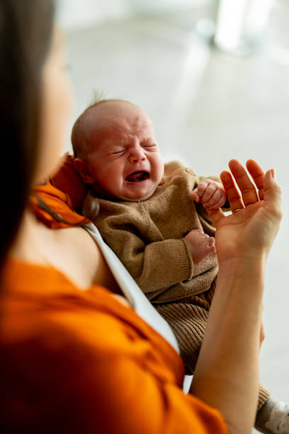istock Newborn baby crying in mother's hands 1989671237