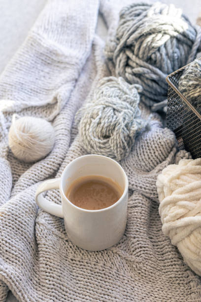 istock Close-up, cup of coffee, knitted element and yarn threads. 1989675477