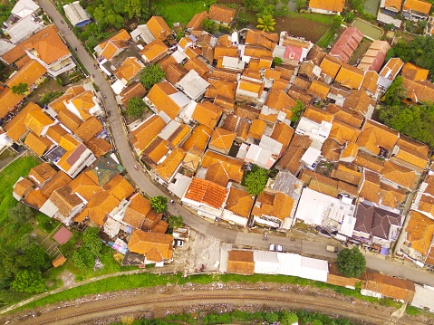 Amazing landscape of Train Tracks. Bird's eye view from drone of a railway line in the middle of densely populated houses in Cicalengka, Indonesia. Shot from a drone flying 200 meters high.