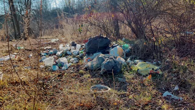 Tourists left trash. A garbage dump in the winter forest. Plastic waste - an environmental problem of pollution.